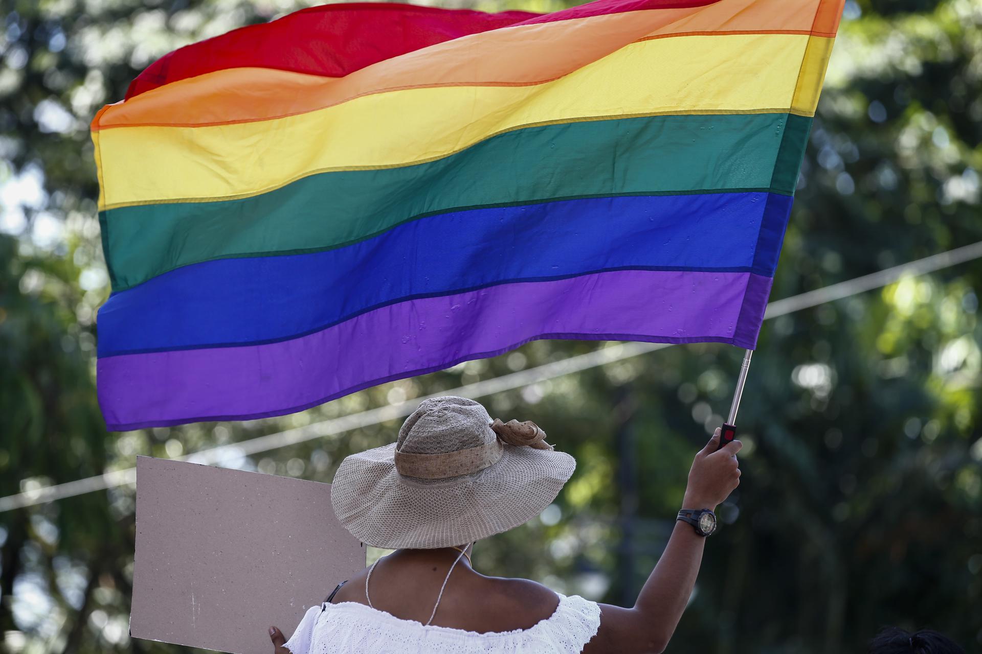 Vista de una bandera LGBTQ+ portada por una mujer, en una fotografía de archivo. EFE/Rolex dela Pena