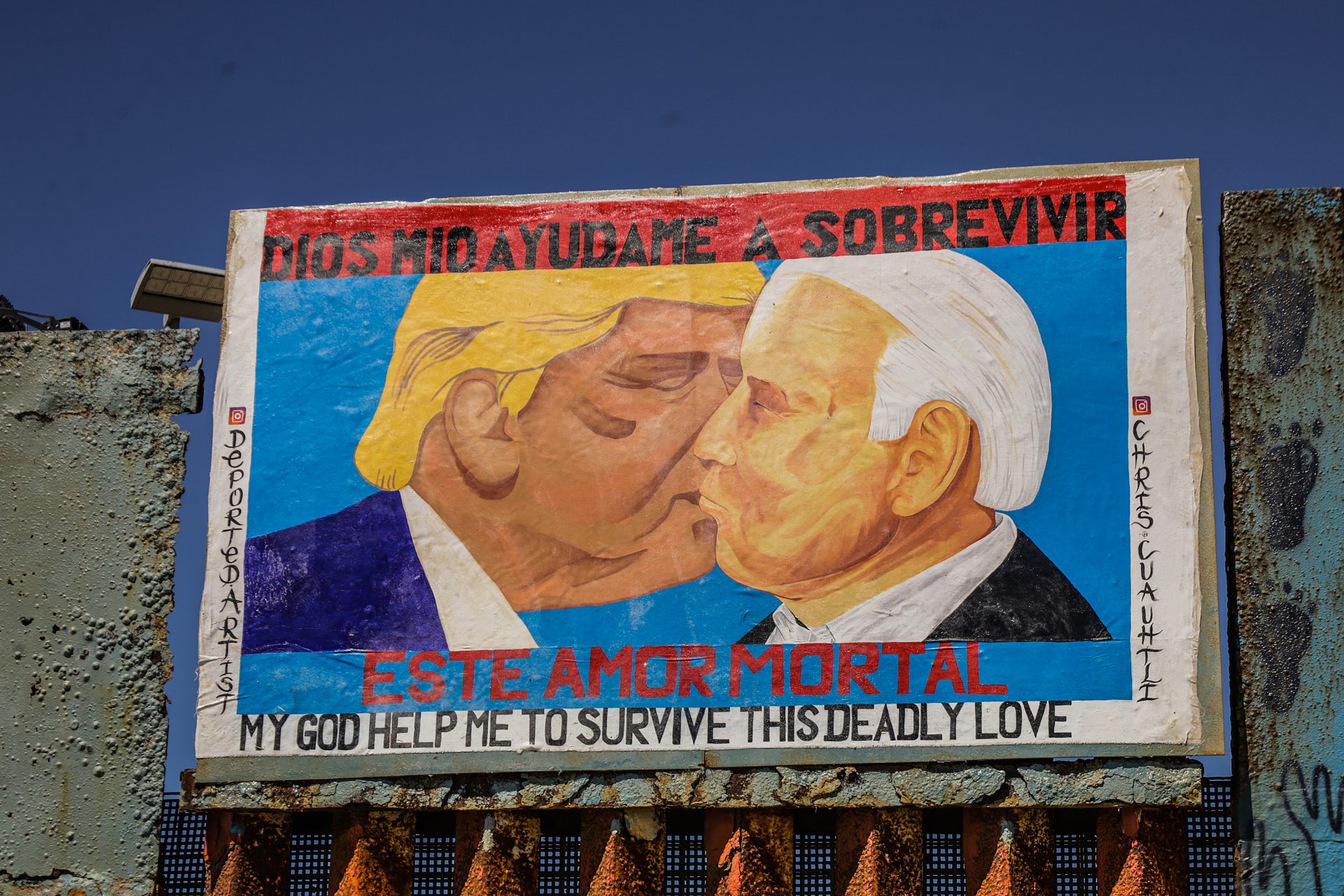 Biden y Trump se besan en una pintura de protesta en el muro fronterizo de México