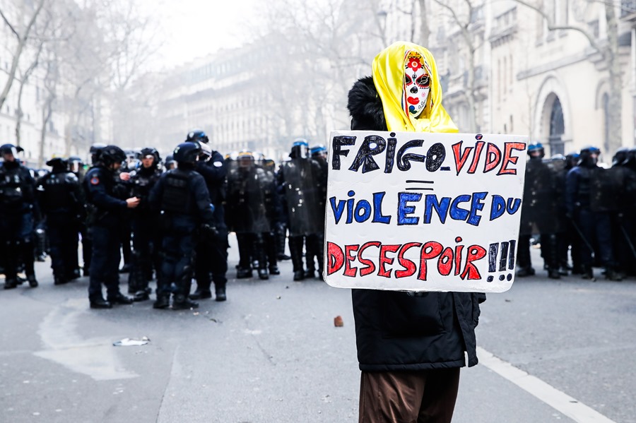 Un hombre lleva un cartel que dice 'Nevera vacía, violencia de la desesperación' durante la manifestación convocada este sábado en París contra la reforma gubernamental del sistema de pensiones.