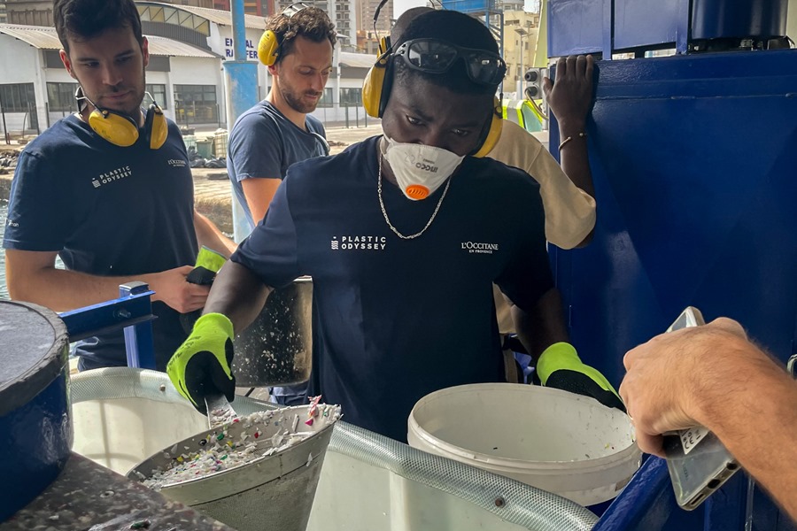  Un miembro del equipo de Plastic Odyssey recoge pequeños trozos de plástico de una máquina durante una formación a emprendedores africanos. 