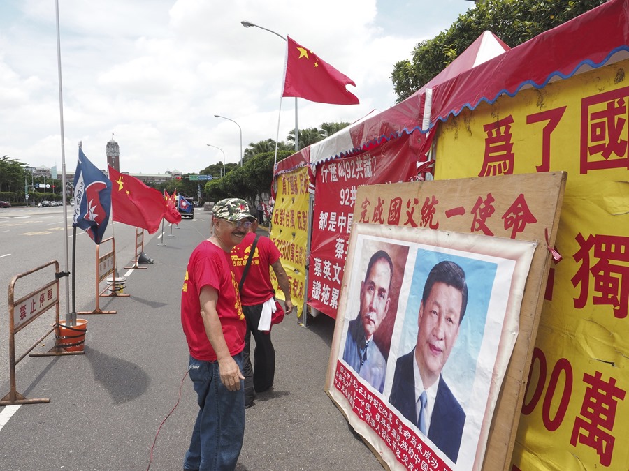 Chou Ching-chun, líder de un grupo pro-chino, mostraba los retratos del presidente chino, Xi Jinping (dcha), y del fundador de la República de China, Sun Yat- en una protesta ante la sede del Gobierno en Taipei en 2017. 