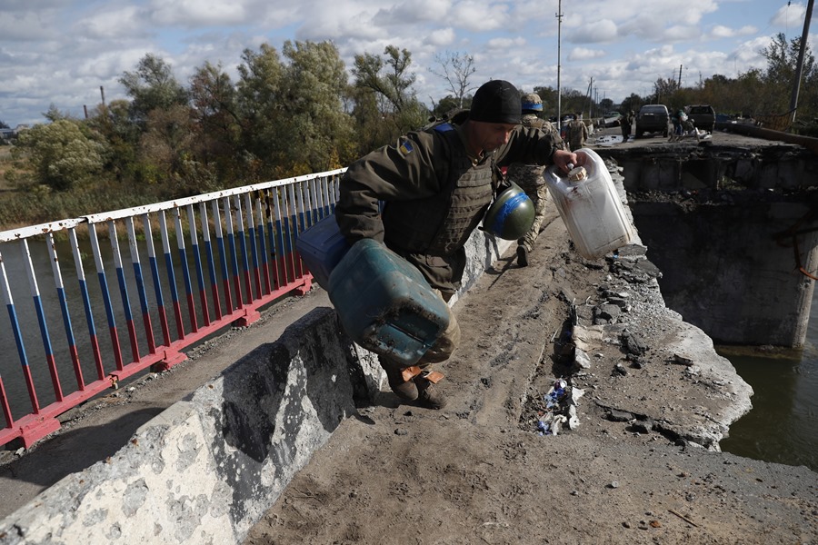 Soldados ucranianos llevaban suministros a través de un puente dañado hacia la ciudad de Kupiansk, tras su liberación el pasado mes de septiembre. 