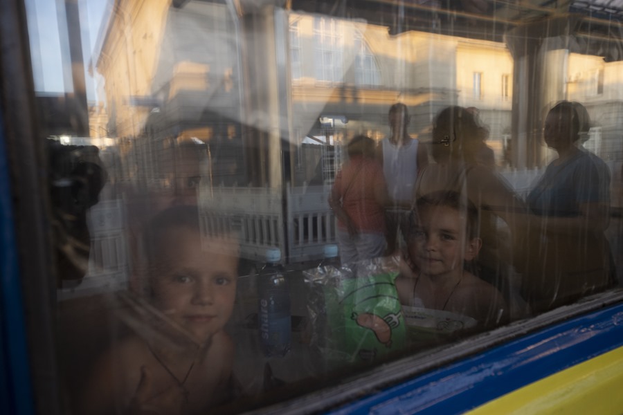 Unos niños miran por la ventana de un vagón de tren en el que feron evacuados de la localidad ucraniana de Dnipro, en una imagen de archivo.