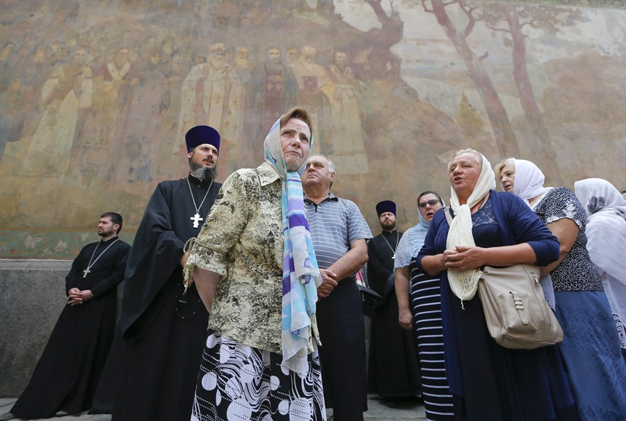 Creyentes ucranianos y monjes ortodoxos del Patriarcado de Moscú en la entrada del Monasterio de las Cuevas de Kiev, en Kiev.