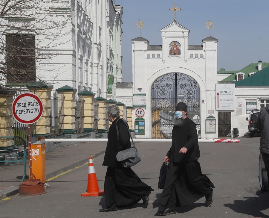 Monjes ortodoxos caminan frente a la entrada del Monasterio de las Cuevas de Kiev.