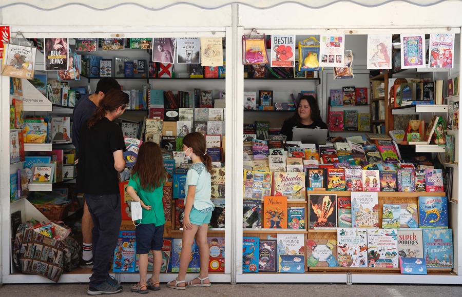 Dos niñas eligen libros en una de las casetas de la Feria del Libro de Madrid, en la edición del pasado año.