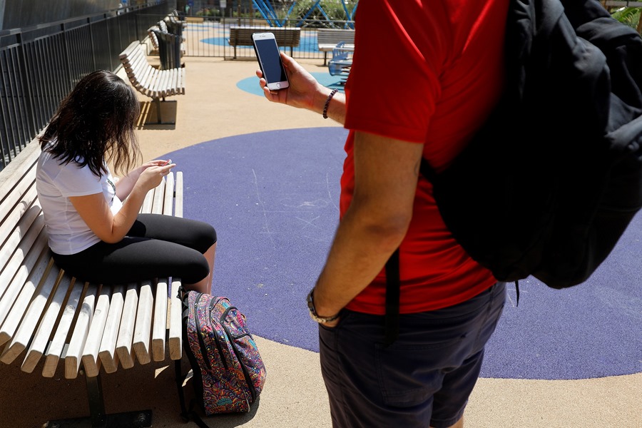 Unos jóvenes usan sus teléfonos móviles en un parque de Niza, en Francia, donde se prevé que las emisiones de CO2 por el uso digital se tripliquen para 2050.