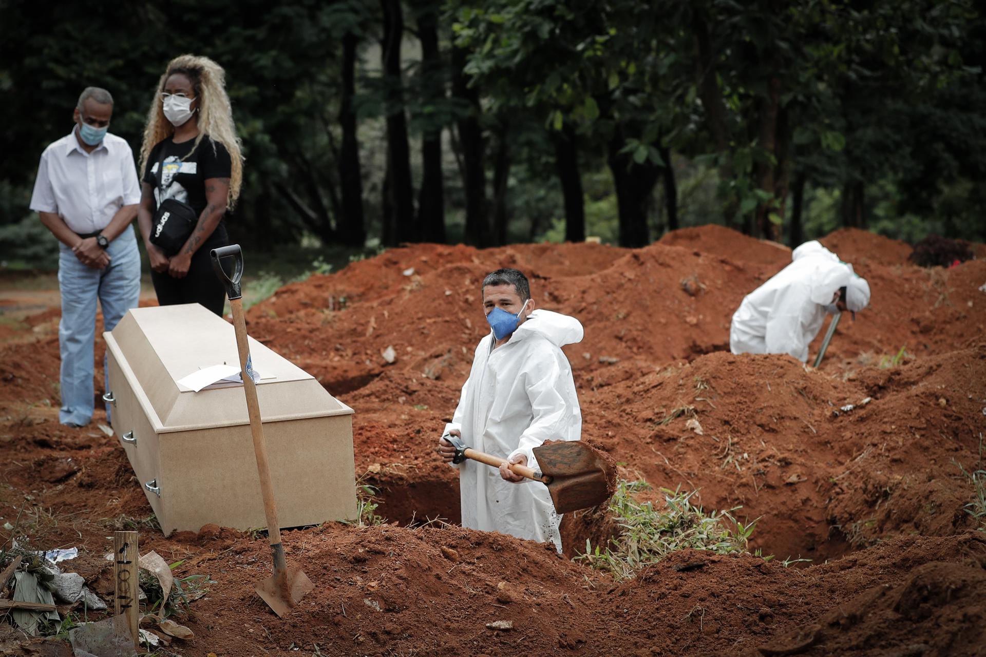 Un trabajador entierra a una víctima de covid-19, mientras familiares se lamentan en el Cementerio Vila Formosa, en Sao Paulo (Brasil), en una fotografía de archivo. EFE/Fernando Bizerra Jr