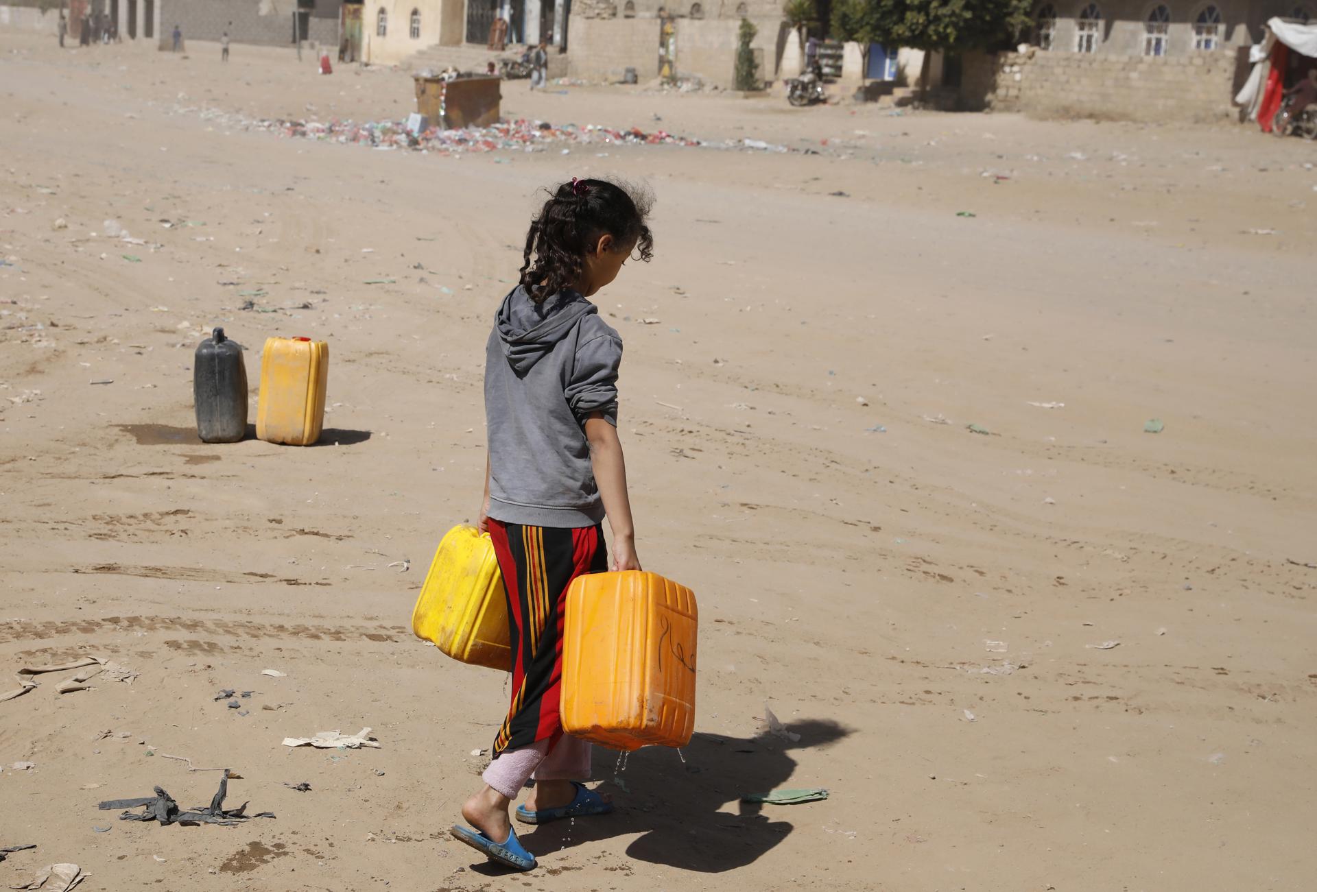 Una niña yemení sostiene recipientes en los que recolectó agua, en una fotografía de archivo. EFE/Yahya Arhab