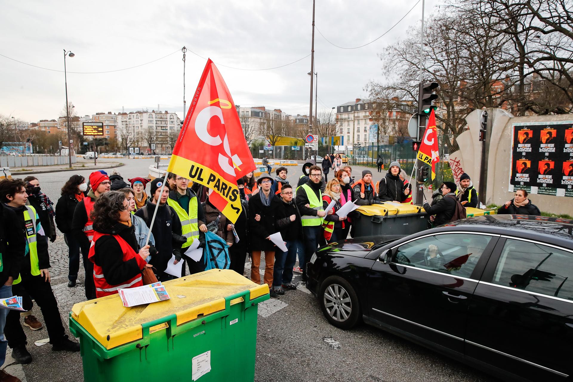 People wave General Confederation of Labour unions (CGT) flags as they block the traffic on Paris' peripheral boulevard in the morning hours to distribute flyers against the French government's pension reform, in Paris, France, 17 March 2023.  EFE/EPA/TERESA SUAREZ