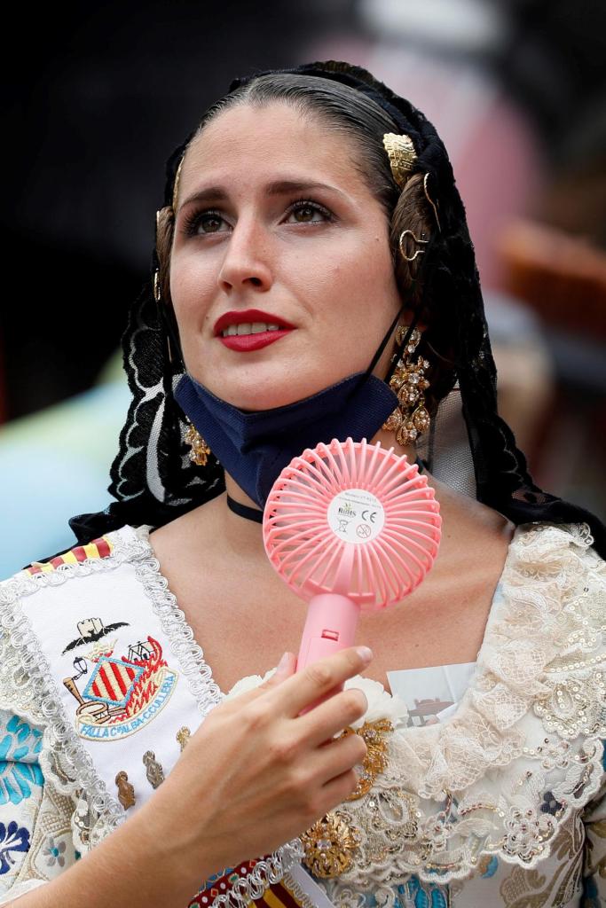 A fallera fights the heat with a fan during the Offering to the Virgin in Fallas.  EFE/Ana Escobar/File