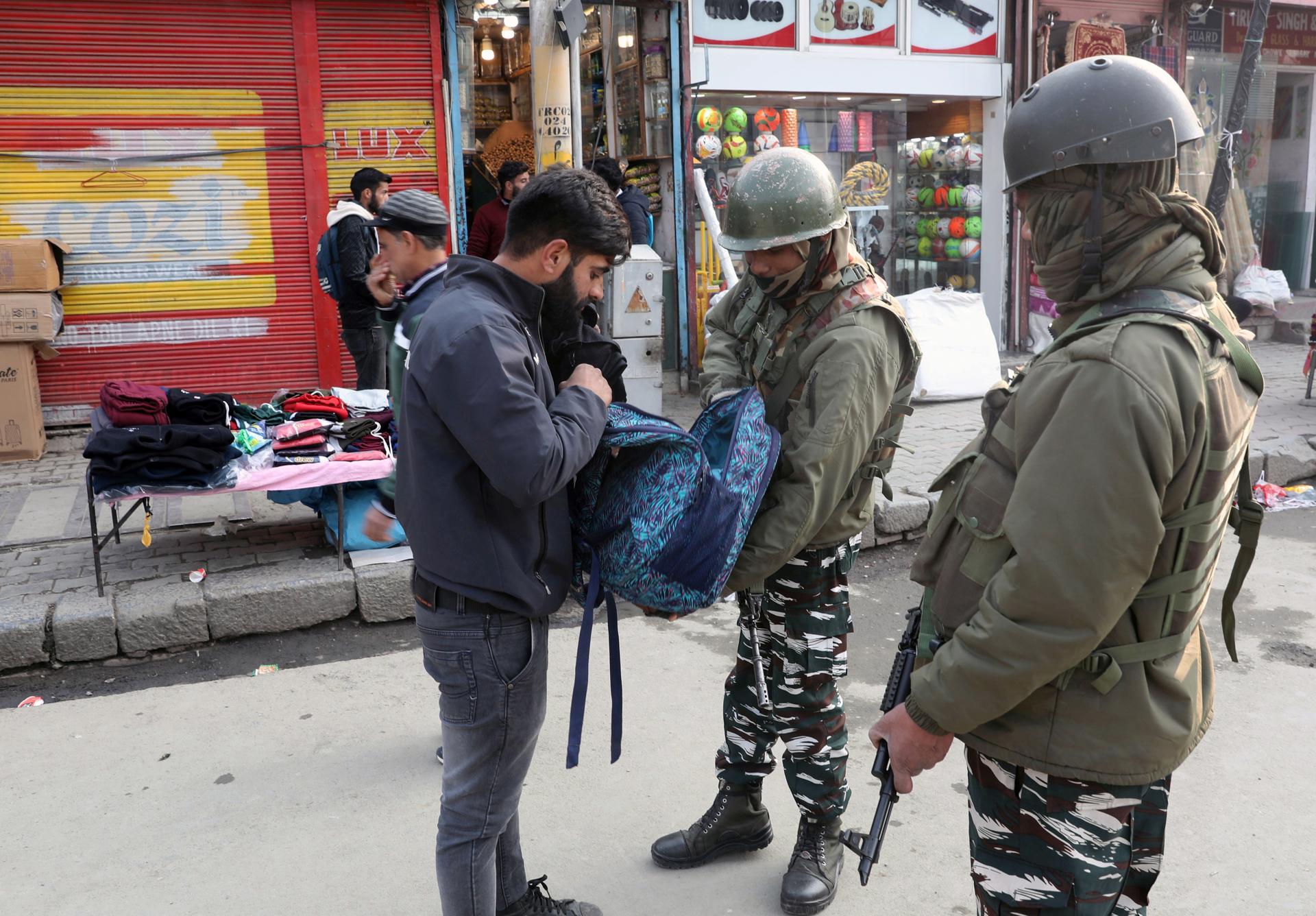 Indian security soldiers check a Kashmiri man's bag during a surprise search operation in central business hub Lal Chowk in Srinagar, India, 21 November 2022. EFE-EPA/FAROOQ KHAN