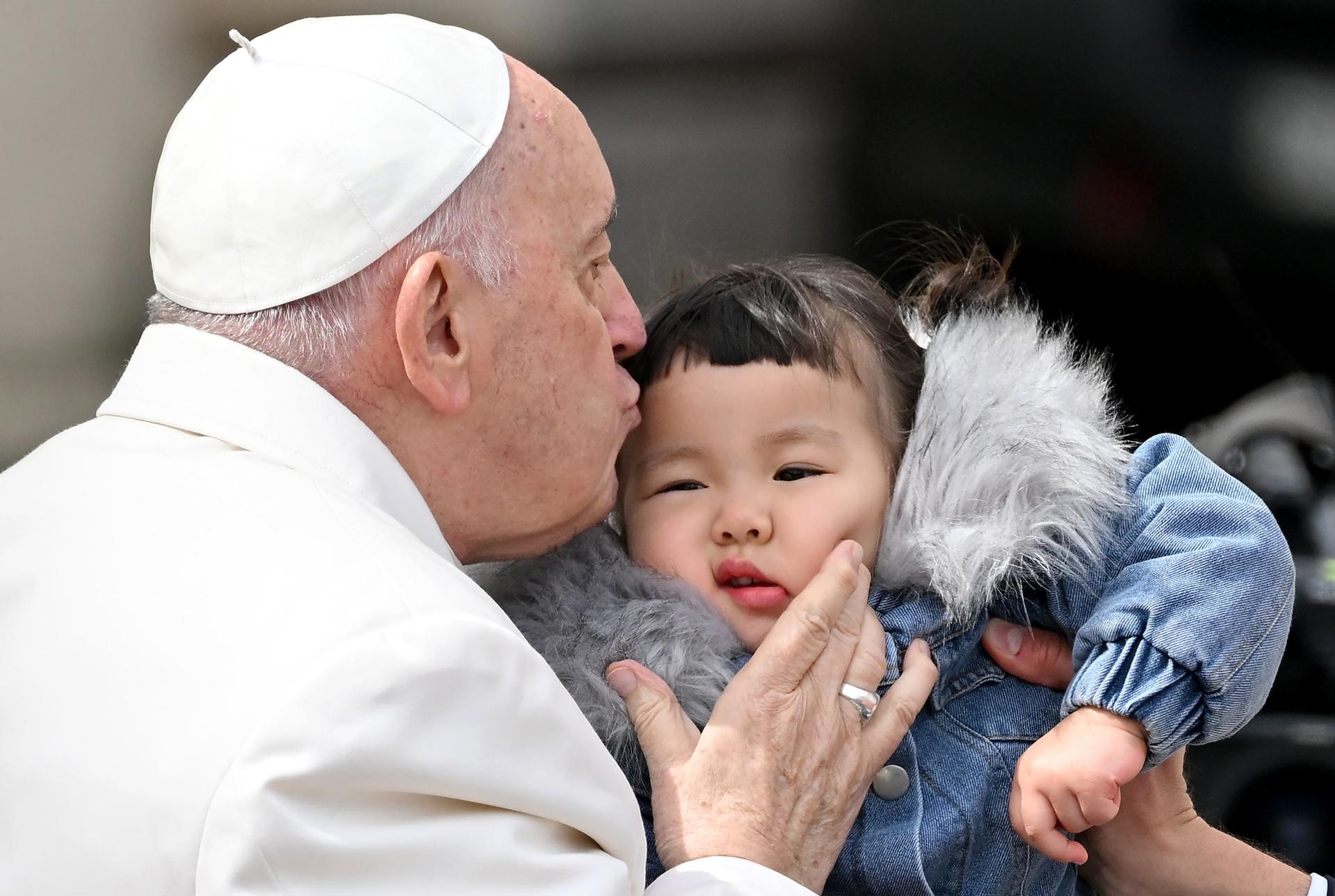 Pope Francis kisses a boy at the end of his weekly general audience in St. Peter's Square in Vatican City on 29 March 2023. EFE/ETTORE FERRARI