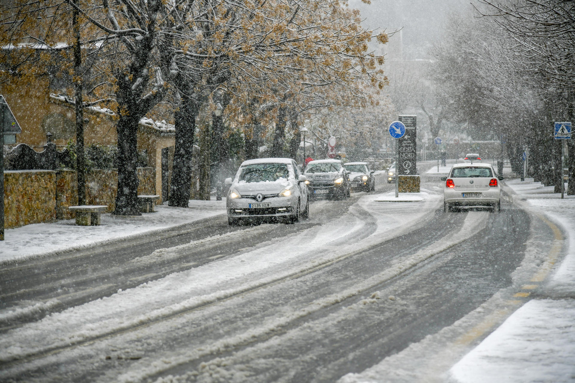 Varios coches circulando esta semana por las calles nevadas de la región mallorquina de Valldemossa. EFE/CATI CLADERA