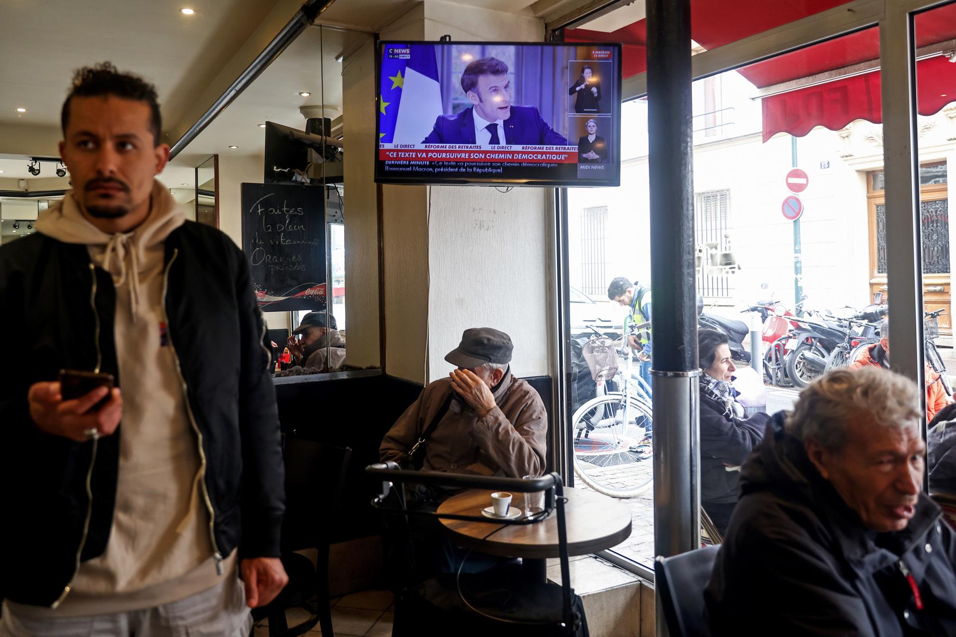A television in a bar shows the French President Emmanuel Macron's televised interview, in Paris, France, 22 March 2023. EFE/EPA/Mohammed Badra