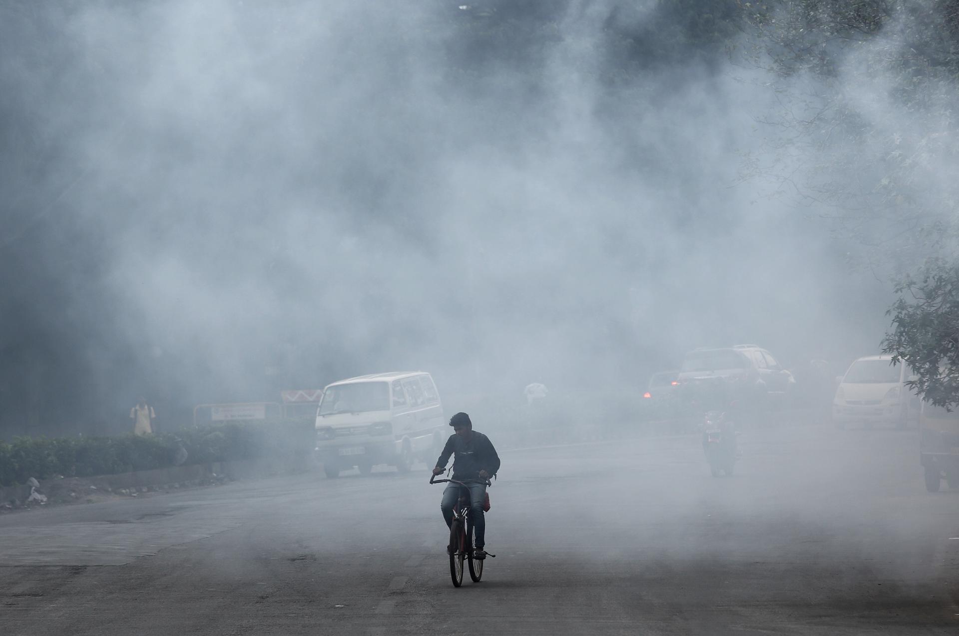 An Indian cyclist pedals into heavy air pollution caused due to a roadside garbage dump, in Bangalore, India, 21 July 2018. EFE-EPA/File/JAGADEESH NV