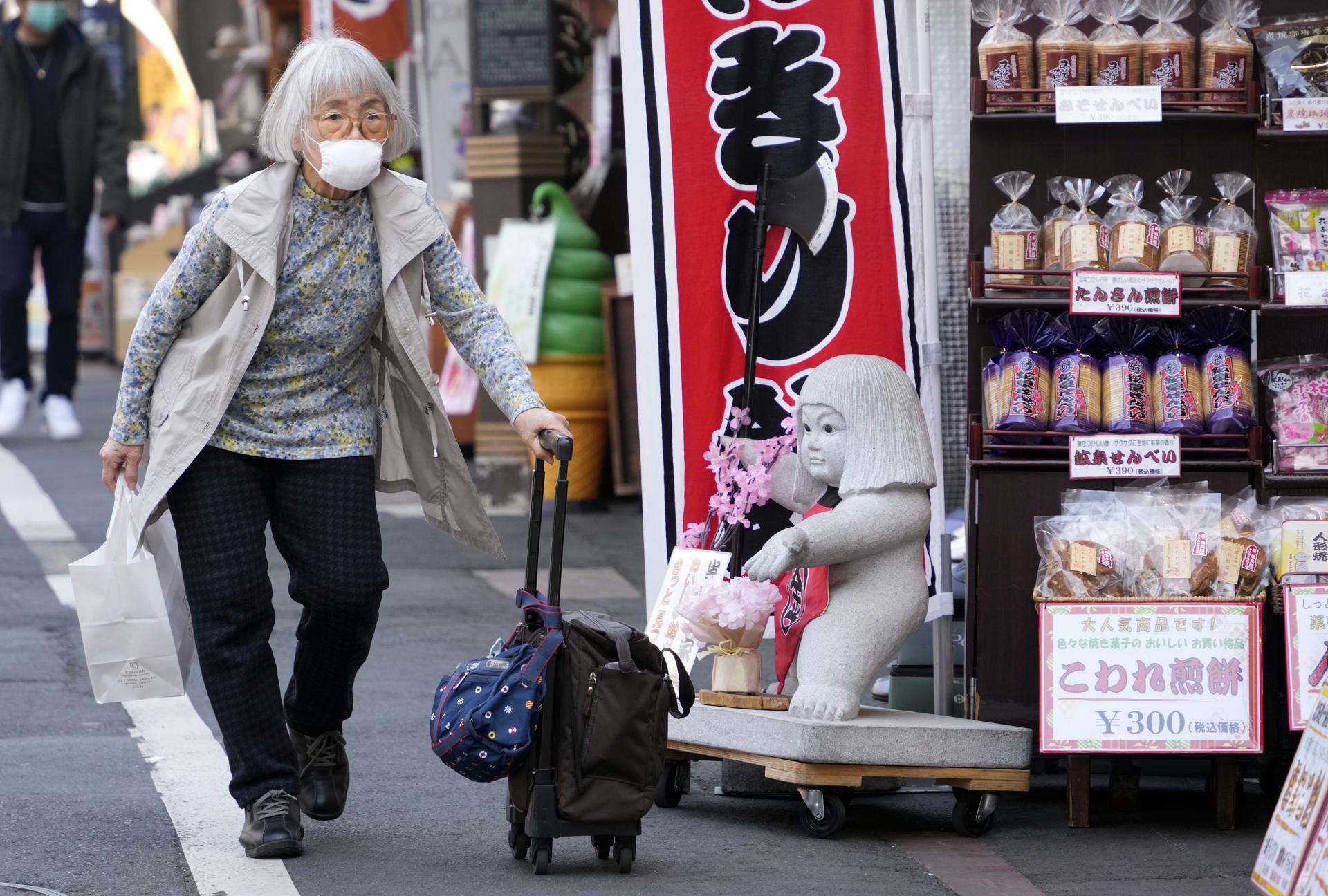An elderly woman walks past a shop in Tokyo, Japan, 09 March 2023 (issued 13 March 2023). EFE-EPA/FRANCK ROBICHON