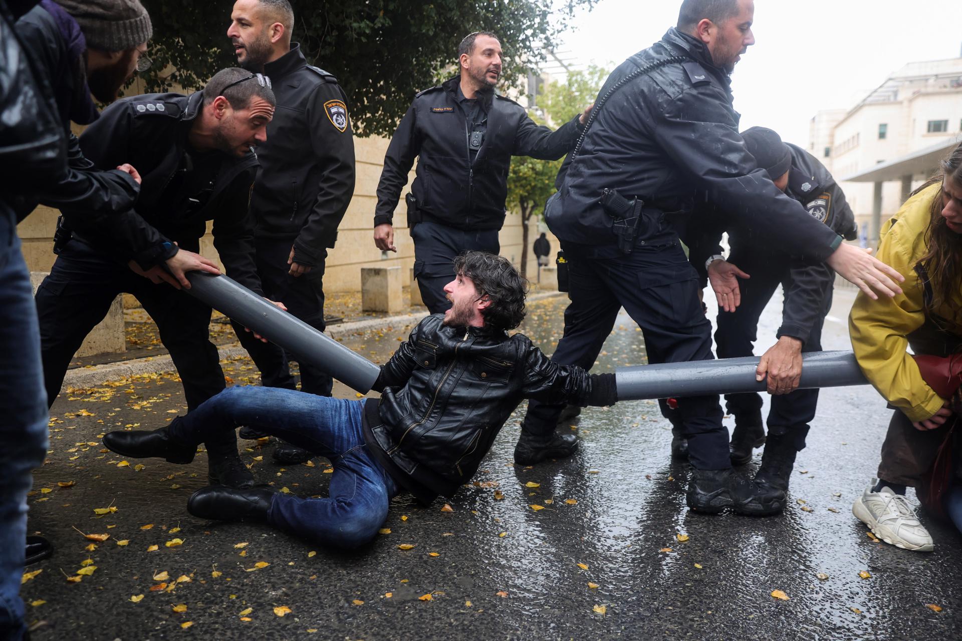 Police tries to separate protesters who tied themeselves with plastic pipes and iron chains outside the Israeli Foreign Ministry in Jerusalem, 14 March 2023. EFE/EPA/ABIR SULTAN