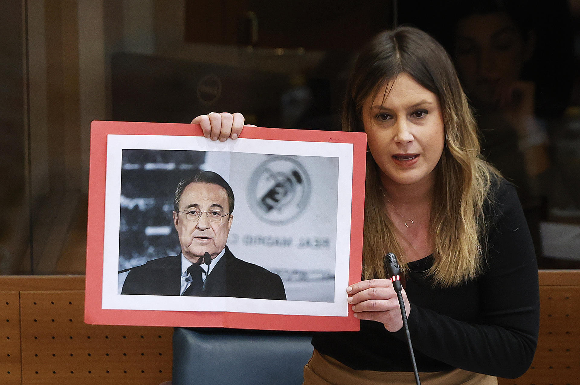 La líder de Unidas Podemos, Alejandra Jacinto, muestra la fotografía de Florentino Pérez en el pleno de la Asamblea de Madrid celebrada este jueves. EFE/Javier Lizón