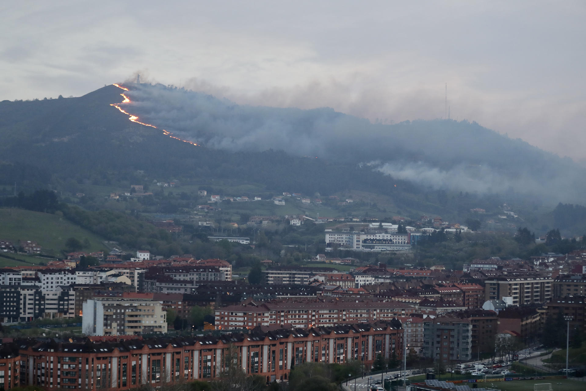 Vista al amanecer del incendio en el monte Naranco de Oviedo. EFE/J. L. Cereijido