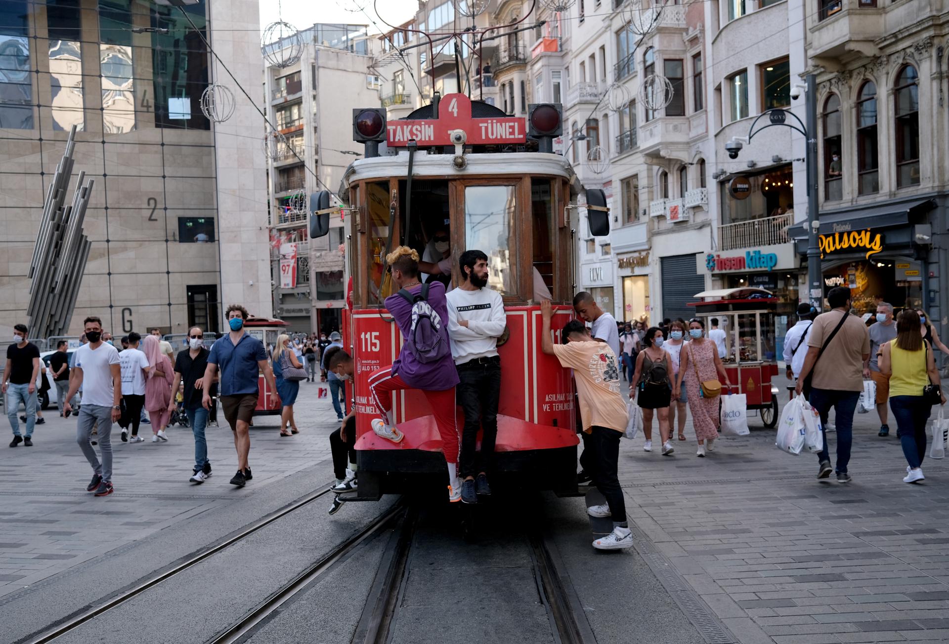 Personas caminan y viajan en tranvía en una calle de Estambul (Turquía). EFE/EPA/SEDAT SUNA/ARCHIVO