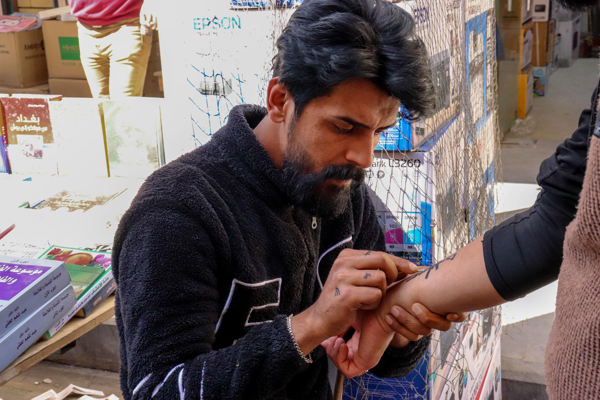 Ali, 29, hand paints temporary tattoos on Al Mutanabbi street in Baghdad, Iraq, 15 March 2023. EFE/Carles Grau Sivera