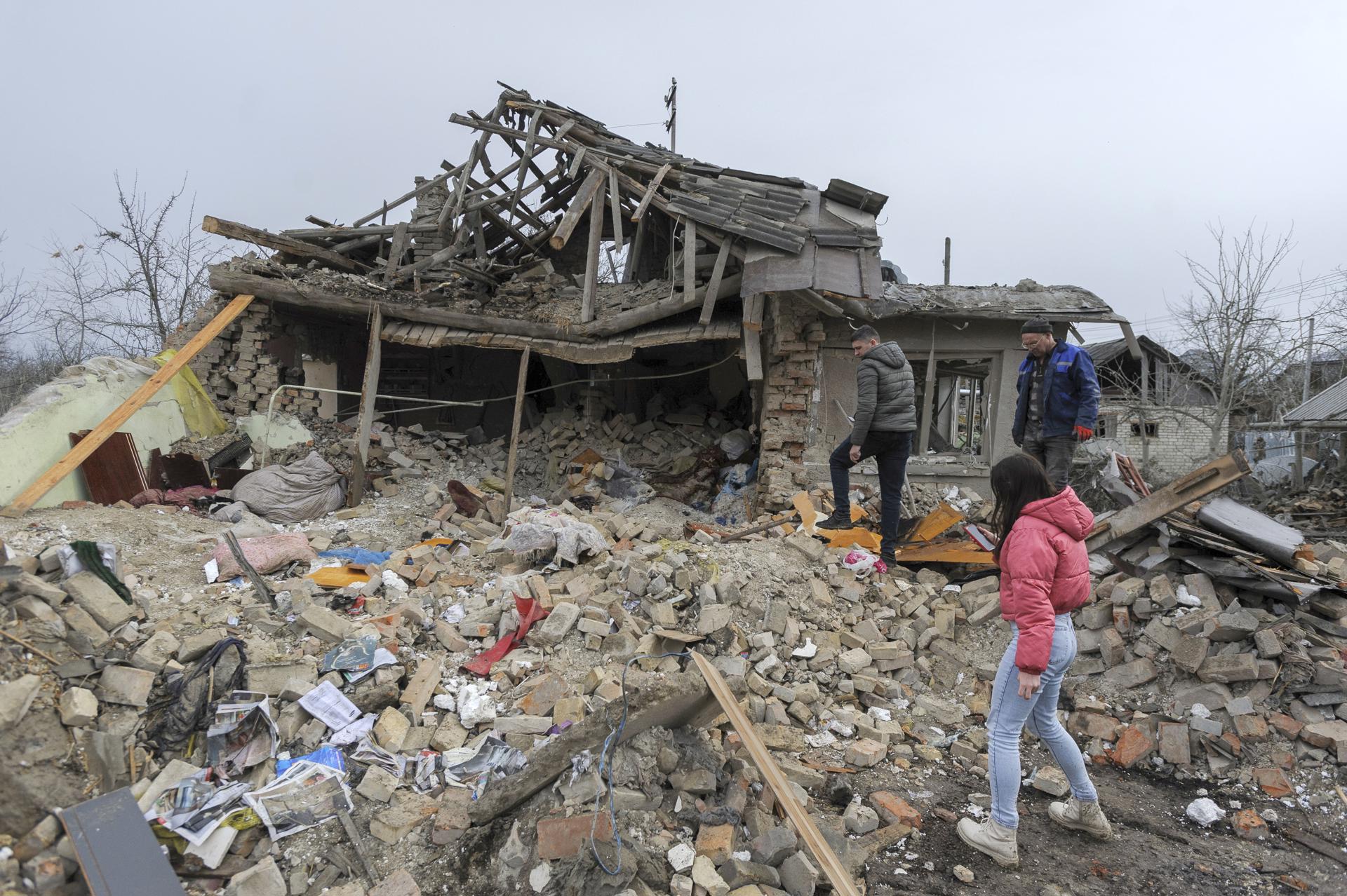 Locals pictured at the scene after two rocket's hit private buildings in the Zolochiv district near the Western Ukrainian city of Lviv, 09 March 2023. EFE-EPA FILE/MYKOLA TYS