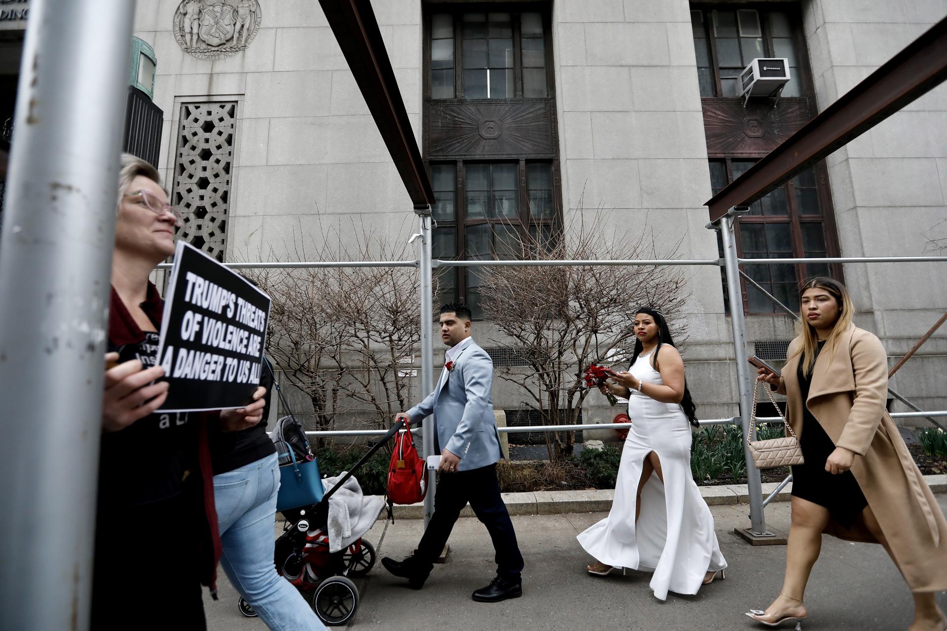 People walk outside the Manhattan Criminal Courthouse in New York while the grand jury examines the case against former President Donald Trump for allegedly making a hush money payment to porn star Stormy Daniels using campaign funds. EFE/EPA/Peter Foley