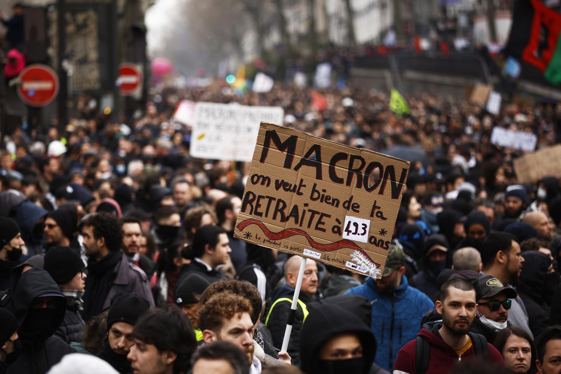 A demonstrator carries a sing 'Macron, we want your retirement at 49.3 years' during the protest against the government's reform of the pension system in Paris, France, 23 March 2023. EFE/EPA/YOAN VALAT