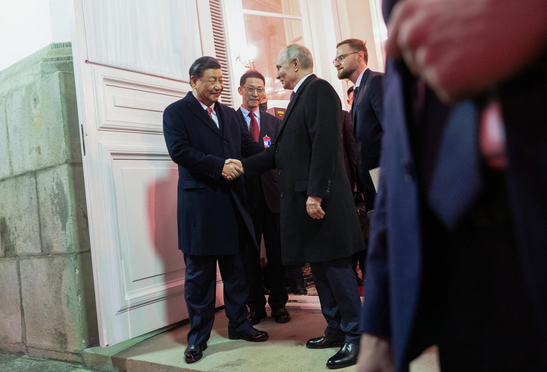 El presidente chino, Xi Jinping (izq.), y el presidente ruso, Vladimir Putin (2-der.), se despiden tras una recepción en honor al líder chino a Moscú, celebrada anoche.