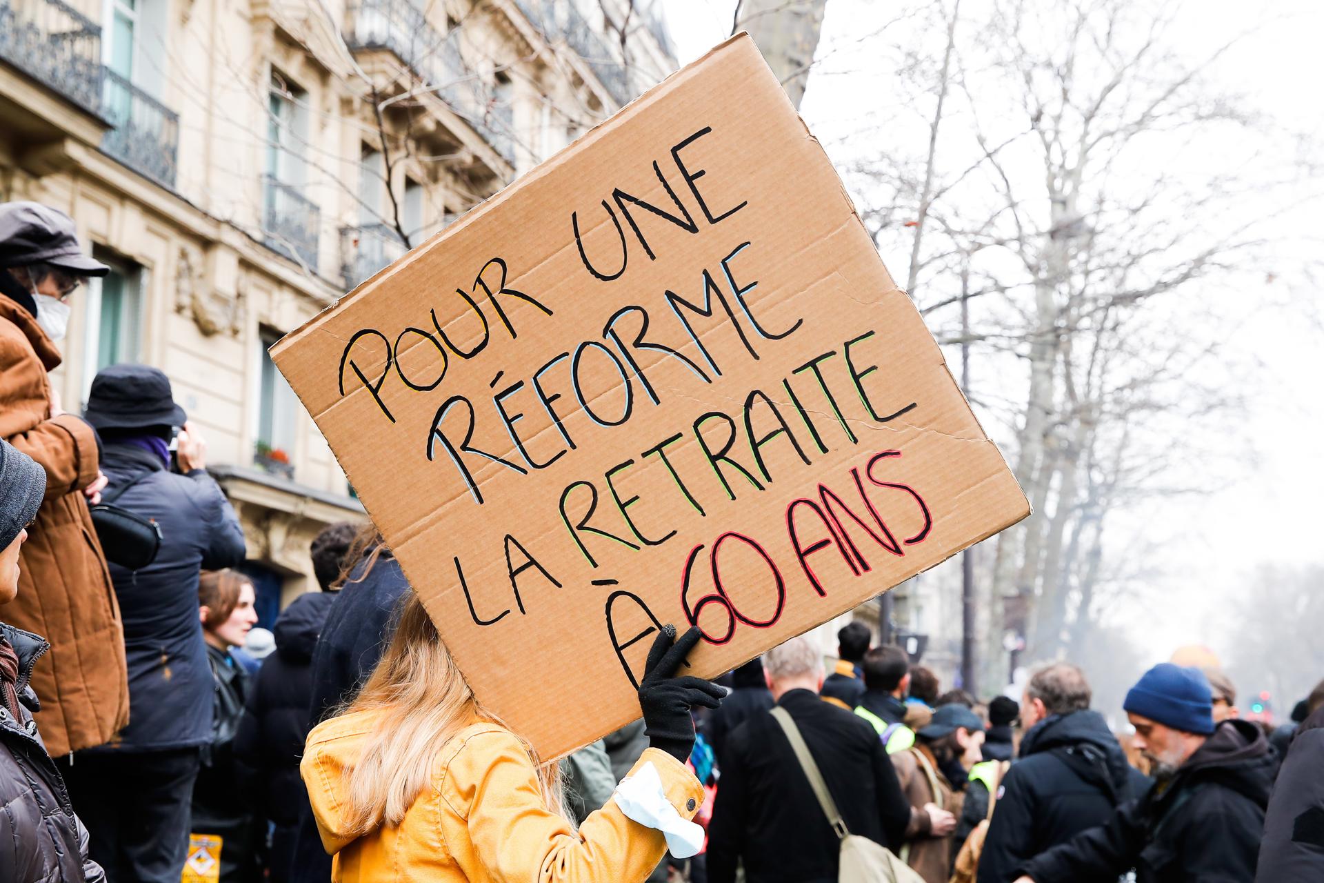 A woman carries a sign that reads 'For a reform of the pensions at 60 years' during the demonstration against the government's reform of the pension system in Paris, France, 11 March 2023. EFE/EPA/TERESA SUAREZ
