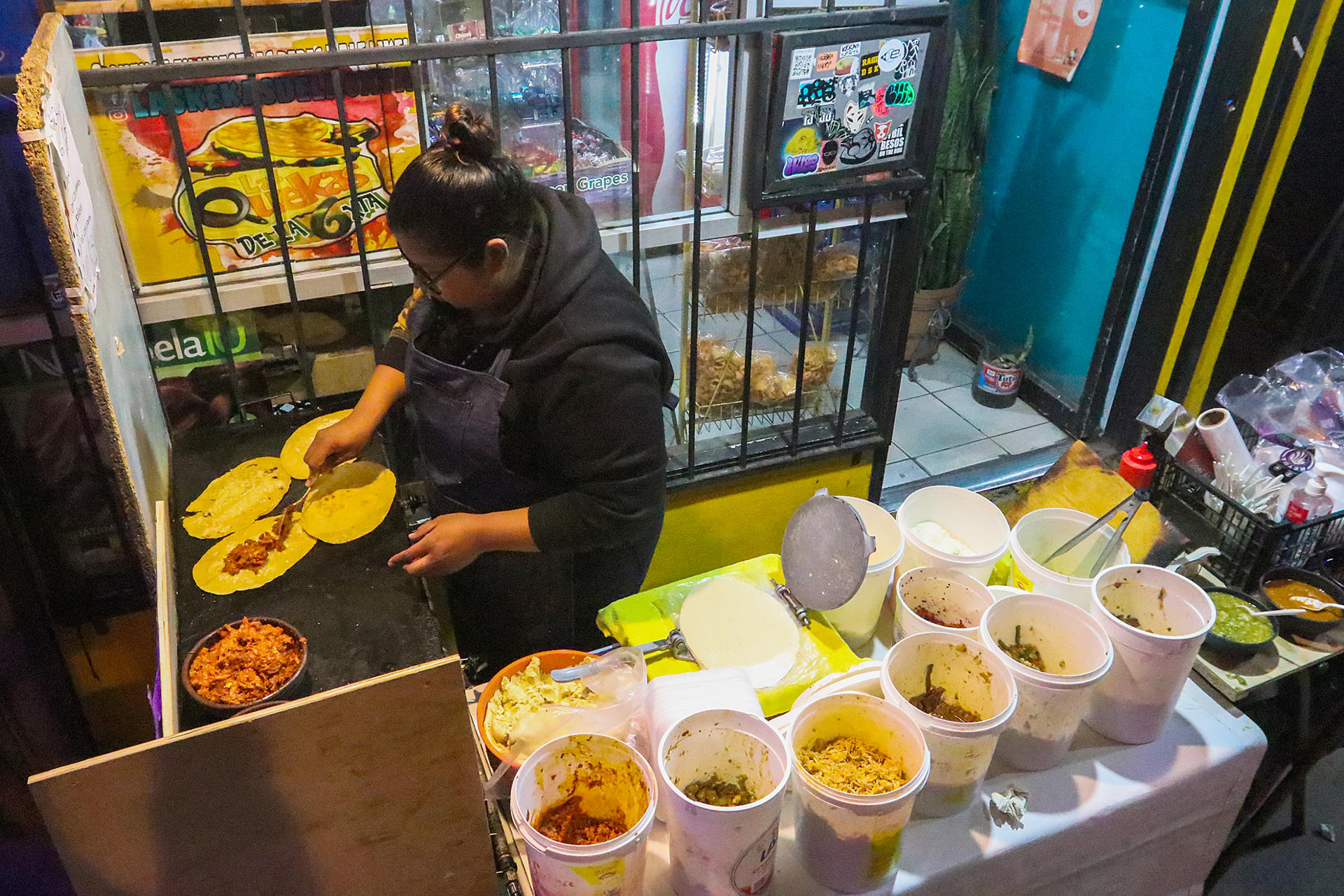 A woman prepares food at a stand in Tijuana, Mexico, on 28 February 2023. EFE/Joebeth Terriquez