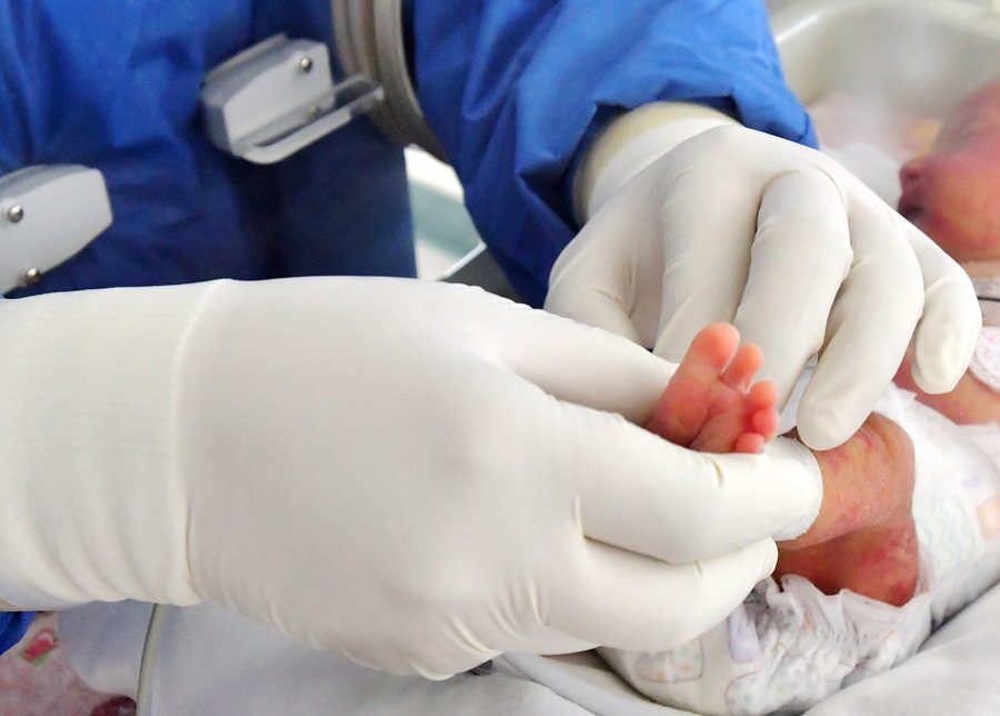 Fotografía de archivo de un sanitario atendiendo a un recién nacido. La salud del padre afecta a la de los hijos