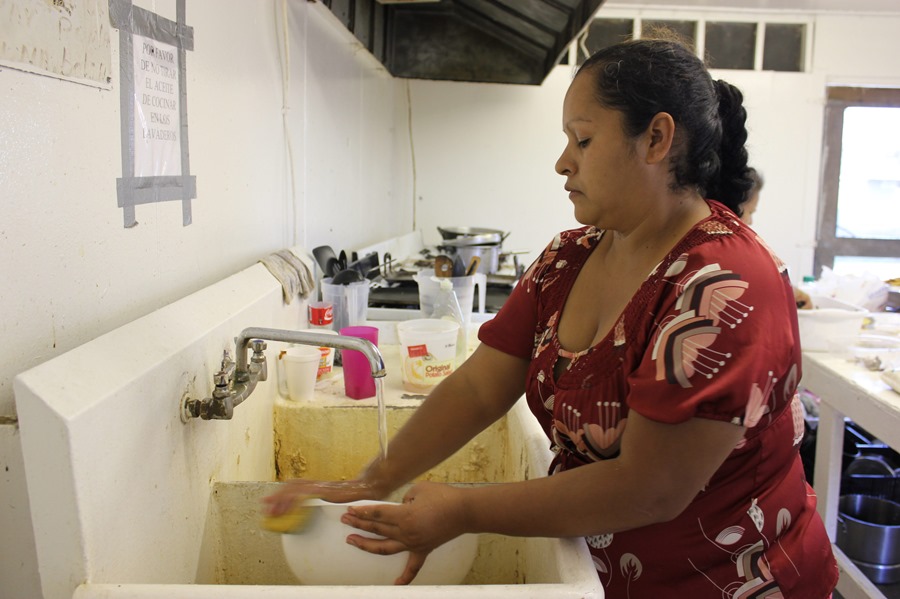 Una mujer limpia los utensilios de la cocina, en una imagen de archivo. Las mujeres siguen liderando las tareas del hogar