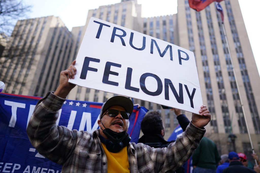 Un manifestante sostiene una pancarta en la que se puede leer "Trump delito" frente a los juzgados de Nueva York, este 4 de abril de 2023. EFE/Will Oliver