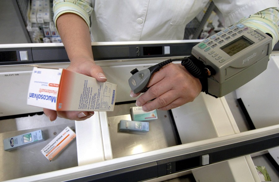 Una mujer escanea con un aparato portátil el código de barras de un medicamento. 
