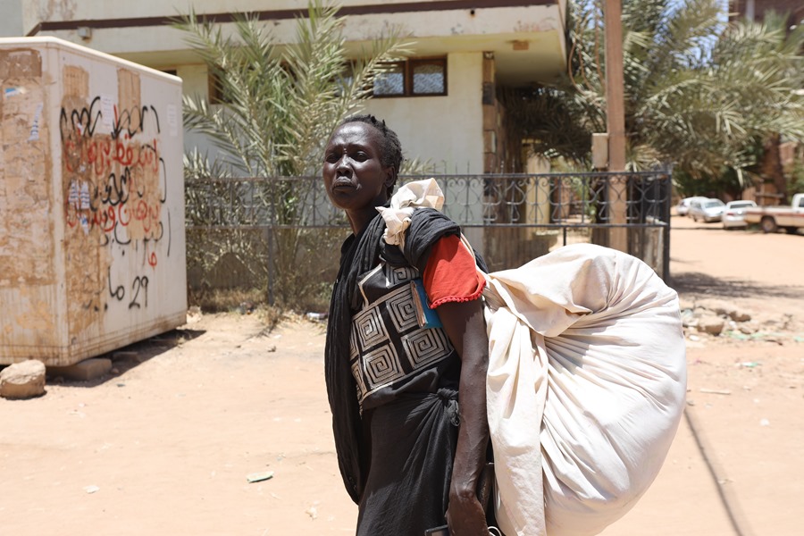 Una mujer camina por una calle de Jartúm (Sudán), donde desde hace días se viven fuertes enfrentamientos armados