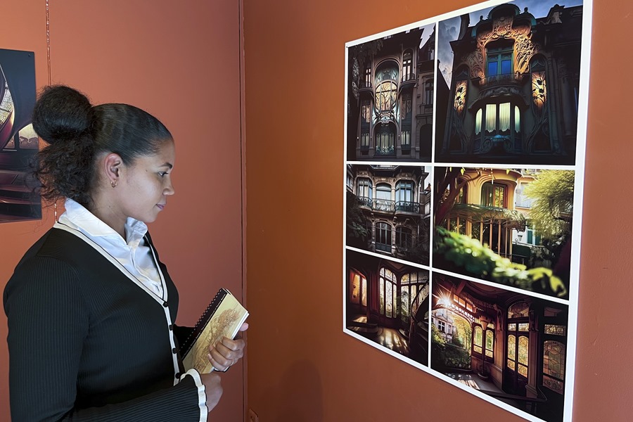 La organizadora de la exposición, Yuni Fajardo, contempla imágenes de edificios creadas por inteligencia artificial, emulando el estilo arquitectónico de Victor Horta, en Bruselas.