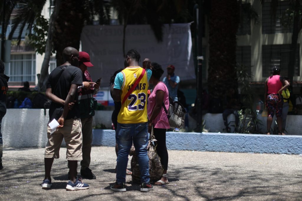 Un grupo de migrantes haitianos permanece frente a las oficinas de la Comisión Mexicana de Ayuda a Refugiados (COMAR), el 14 de abril de 2023, en Ciudad de México (México). La crisis migratoria alcanza a una Ciudad de México saturada. EFE/Sáshenka Gutiérrez