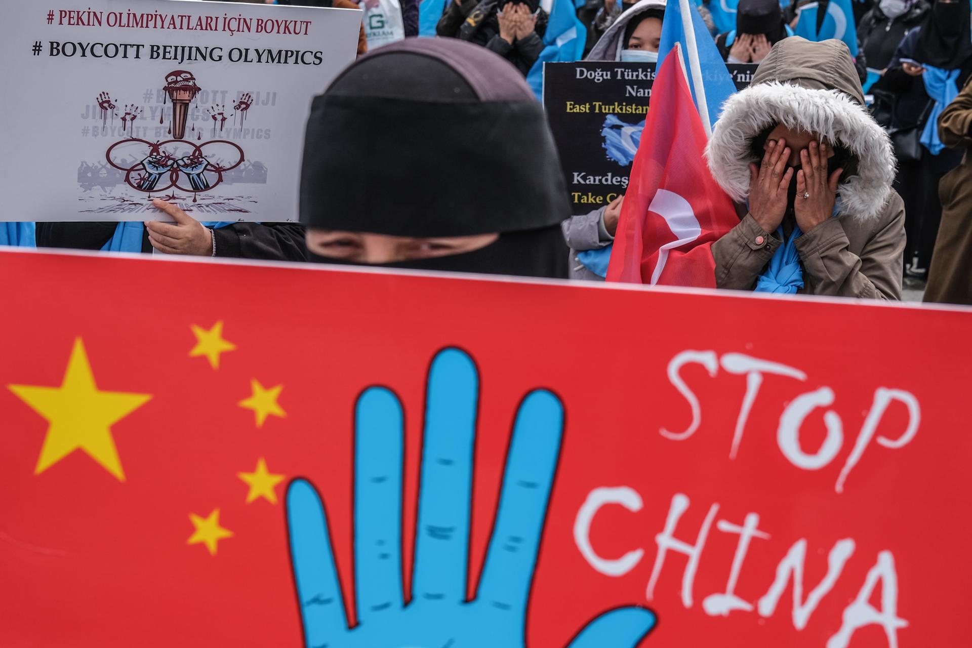 Uyghur protestors who have not heard from their families living in East Turkestan hold placards and Uyghur flags during a protest against China, in Istanbul, Turkey, 25 March 2021. EFE-EPA FILE/SEDAT SUNA
