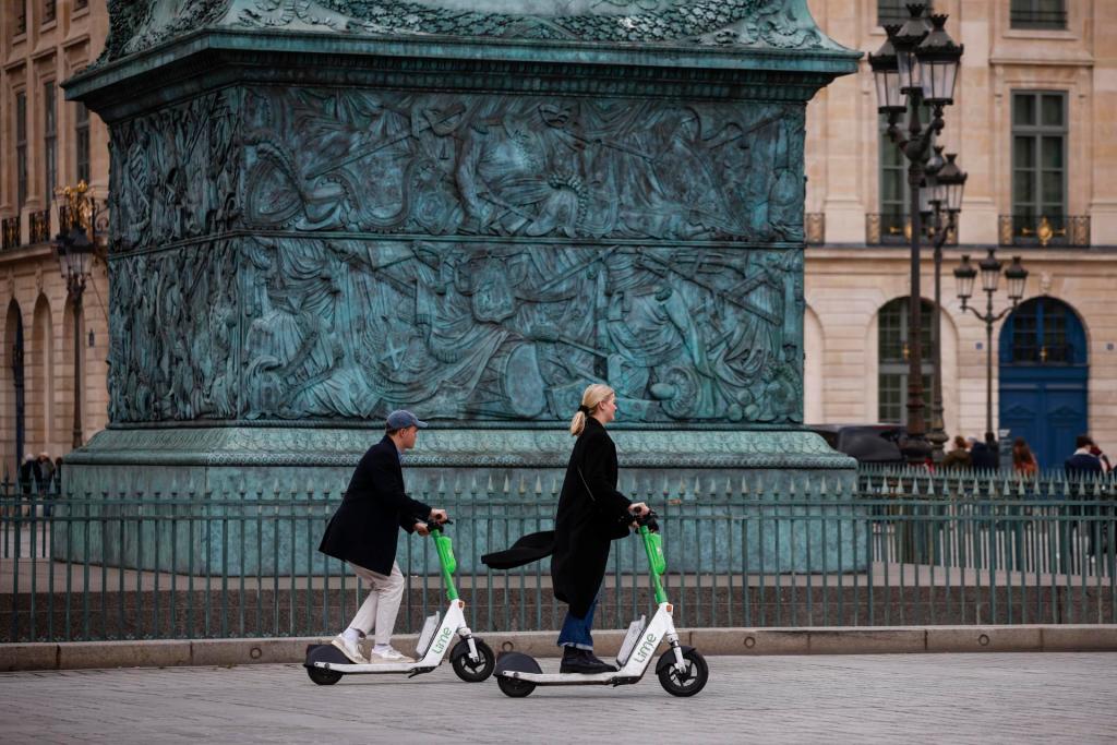 Personas viajan en patinetes eléctricos en París, Francia.