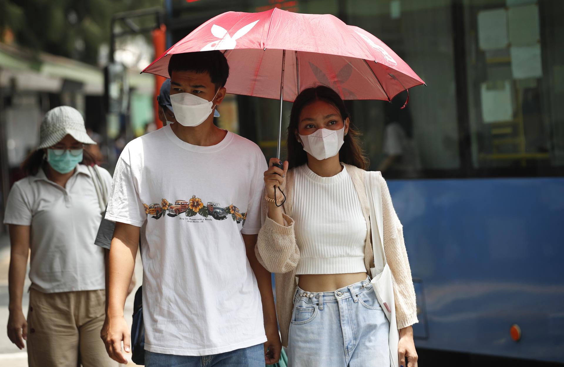 Pedestrians shield themselves from the sunlight under an umbrella during hot weather in Bangkok, Thailand, 23 April 2023. EFE/EPA/RUNGROJ YONGRIT