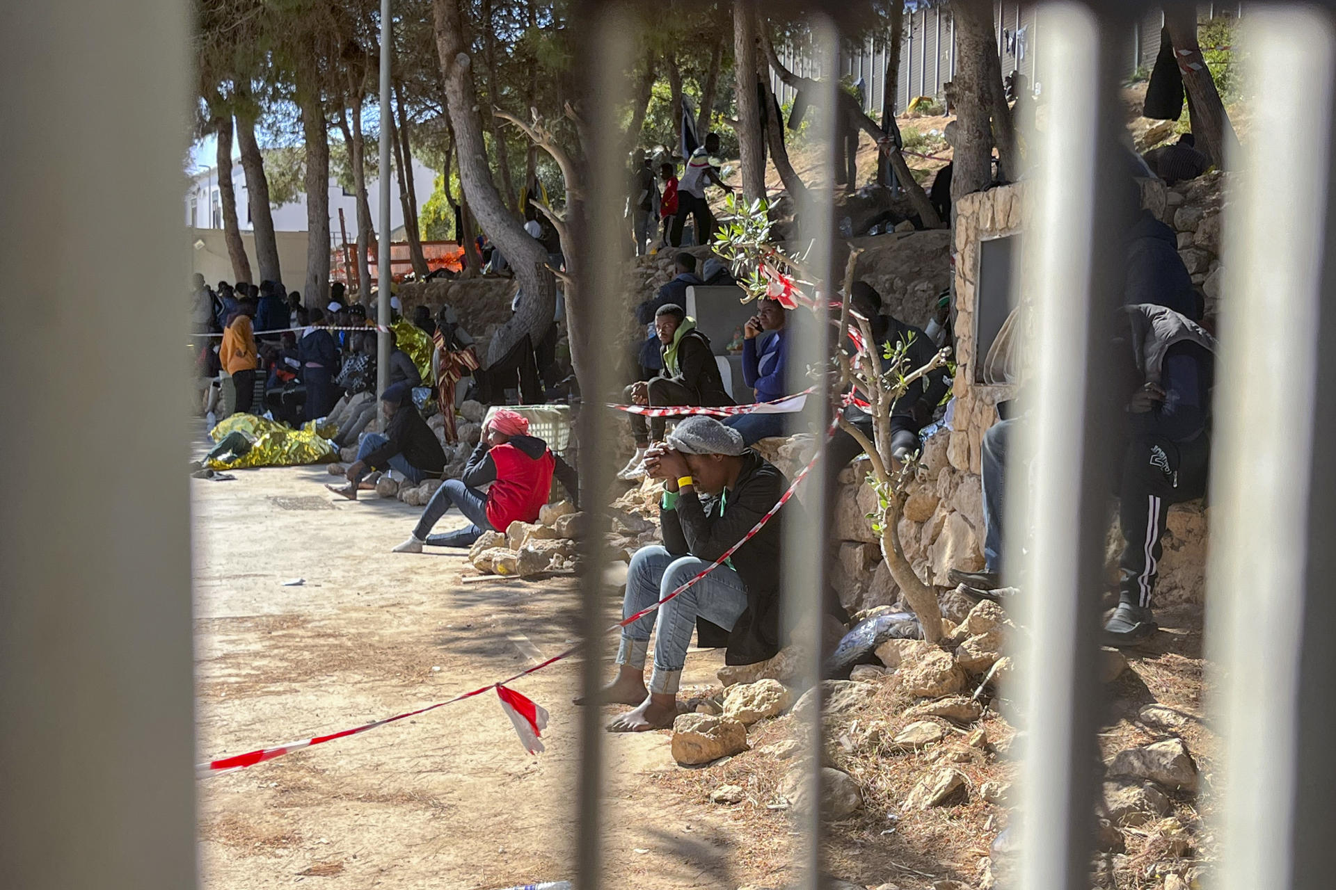 Varias personas permanecen en el interior del centro de acogida de inmigrantes de la isla italiana de Lampedusa. EFE/ Gonzalo Sánchez

