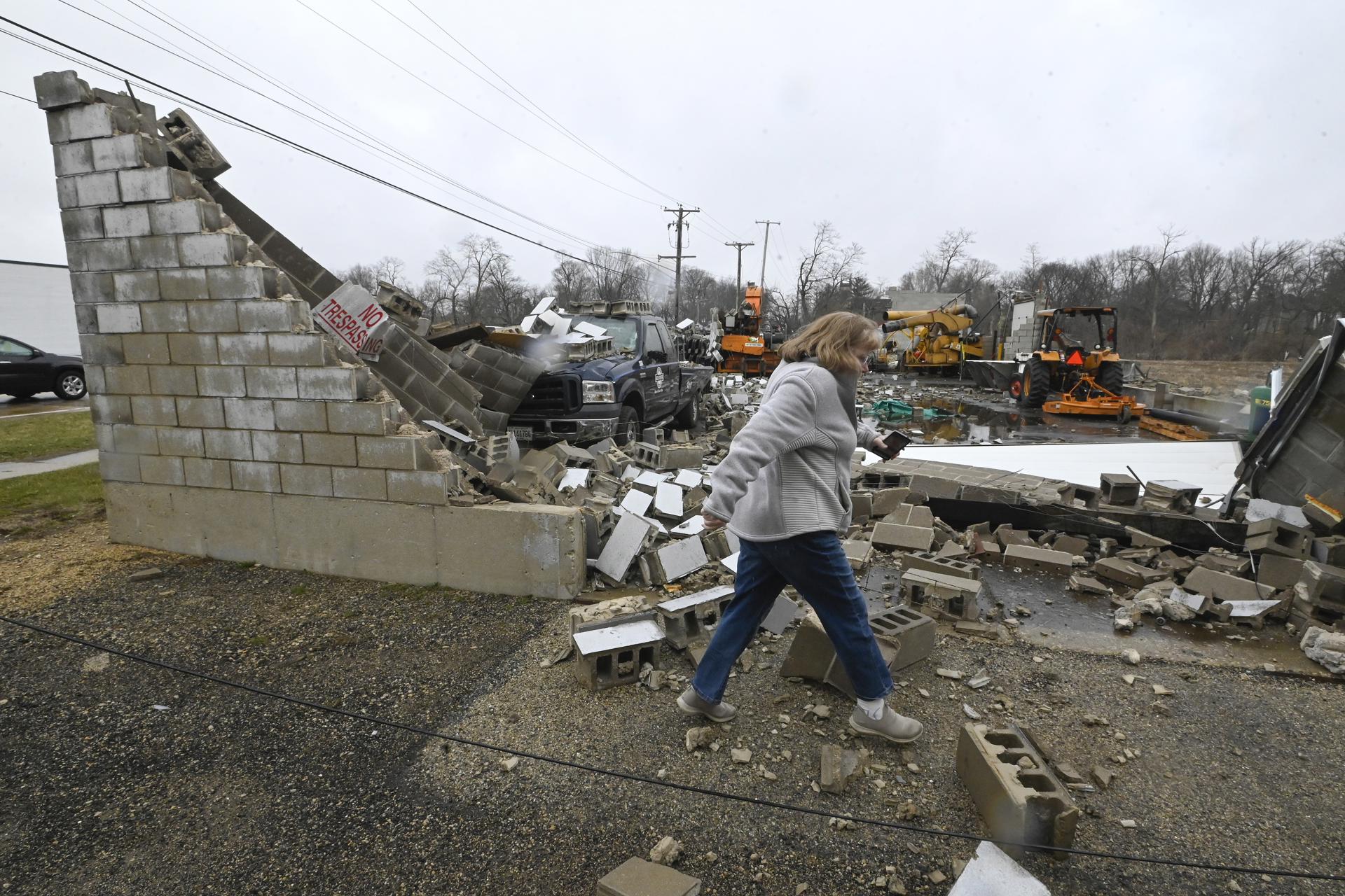 Una mujer pasa frente a un negocio destruido tras un tornado en Belvidere, Illinois, EE.UU,  este 1 de abril de 2023. EFE/EPA/Matt Barton