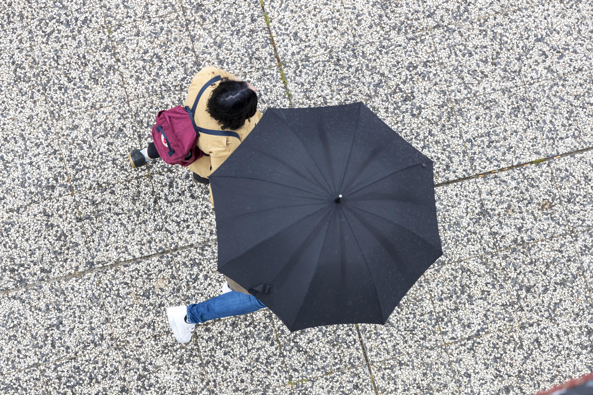 Unas personas se protegen con un paraguas bajo una ligera lluvia en Zaragoza este sábado. EFE/Javier Belver