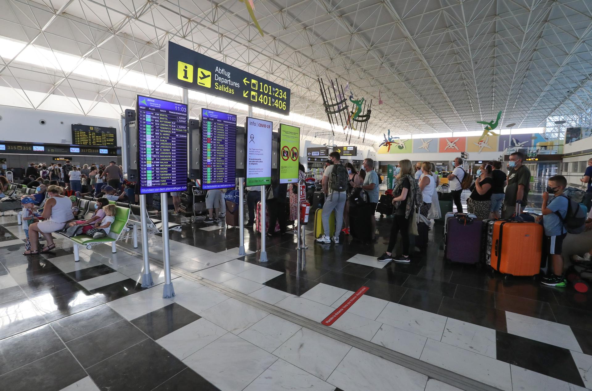 Cientos de turistas hacen cola en el Aeropuerto de Gran Canaria para tomar los vuelos de regreso a sus países. EFE/ Elvira Urquijo A.