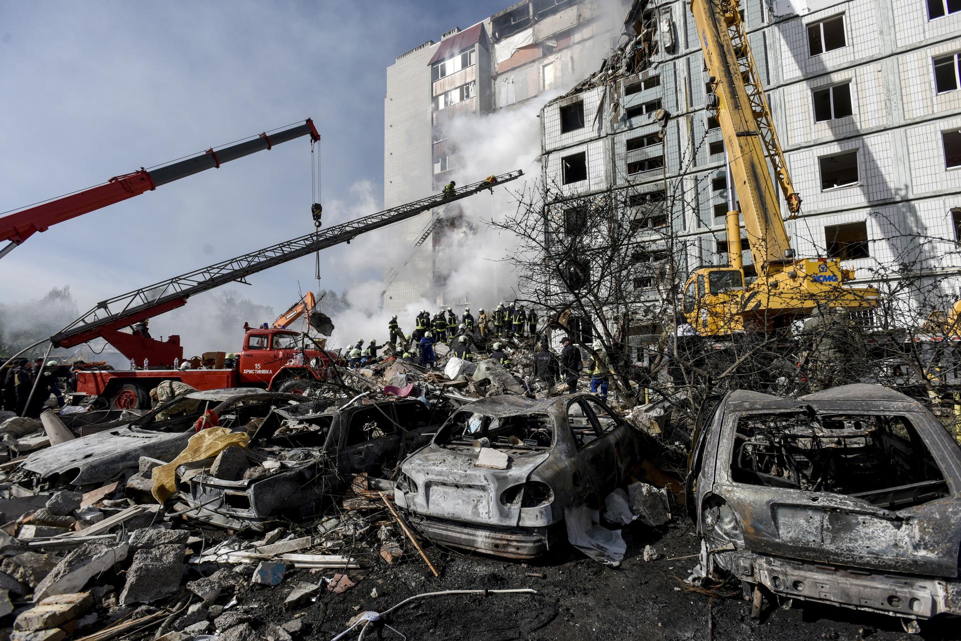A view of destroyed cars (front) as rescuers work at the site of a damaged residential building after a missile attack, in Uman, Cherkasy region, central Ukraine, 28 April 2023, amid Russia's invasion. EFE/EPA/OLEG PETRASYUK