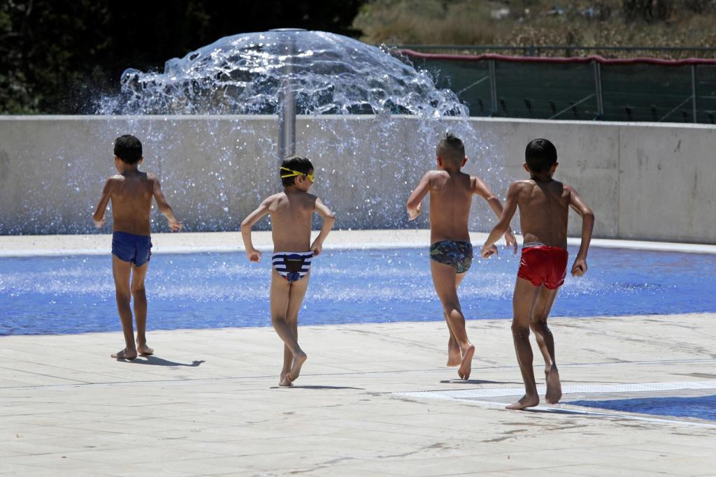 Unos niños se refrescan en la "Piscina de Can Titó", en Vilanova del Camí, una de las piscinas de la comarca de la Anòia (Barcelona),