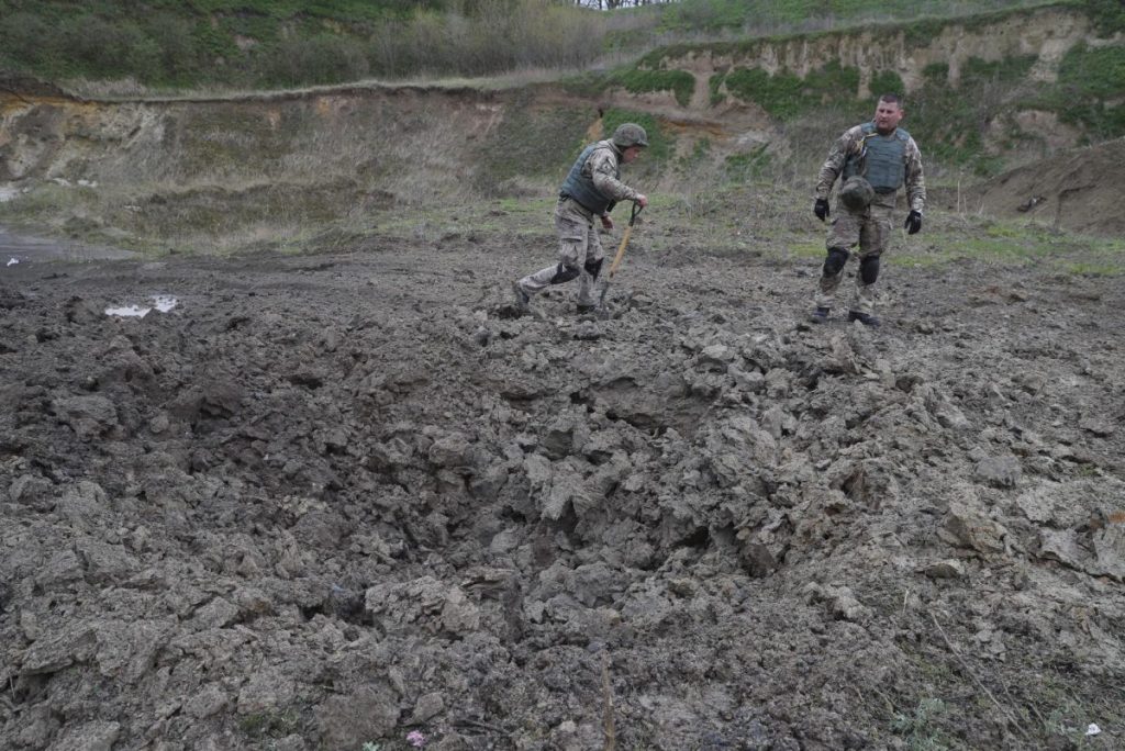 Zapadores ucranianos inspeccionan un cráter tras la explosión de minas antitanque y otros materiales explosivos encontrados cerca de la ciudad de Bucha, en las afueras de Kiev, Ucrania.