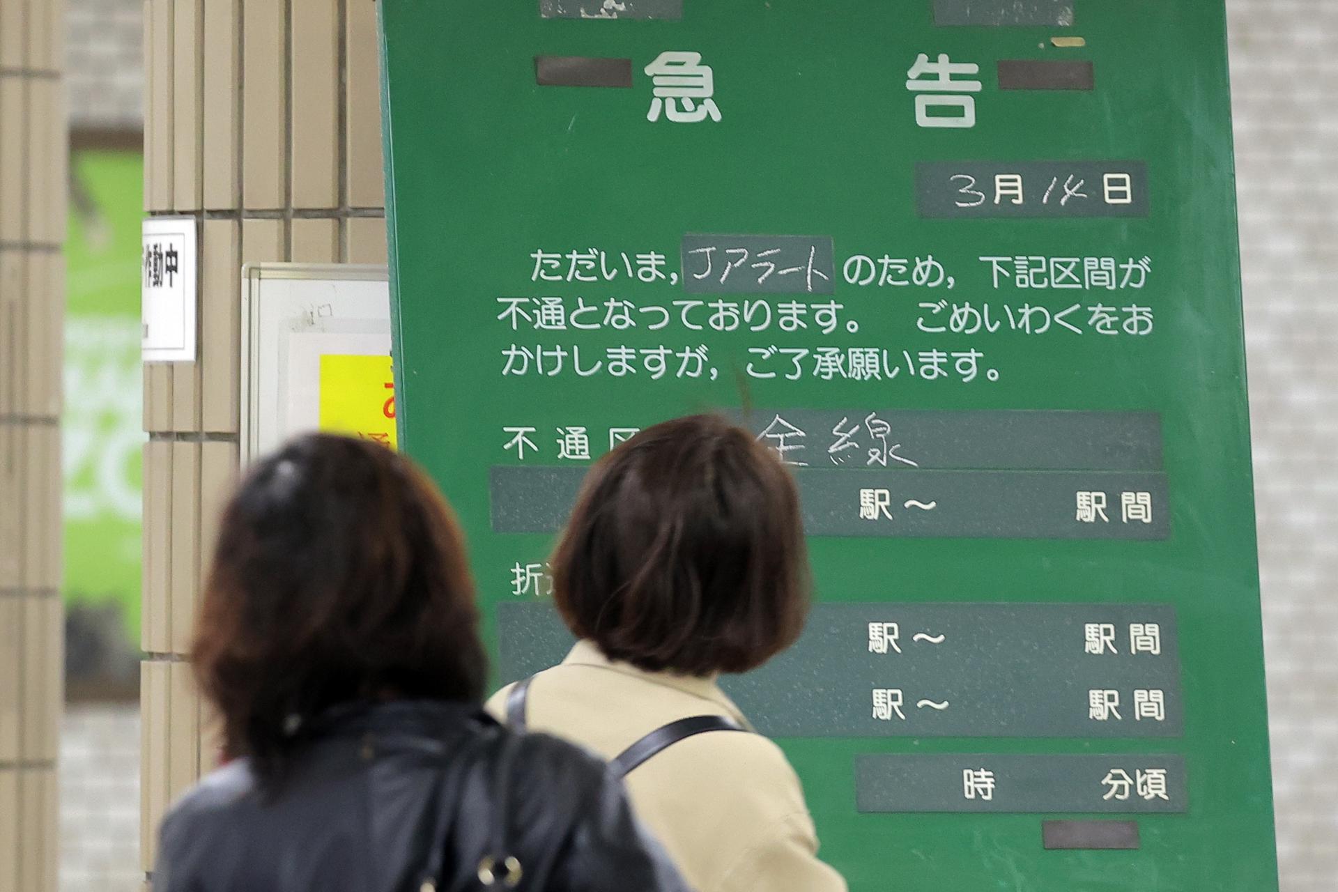 Commuters look at a board announcing the suspension of train service after the government issued the 'J-Alert' at a subway station in Sapporo, Hokkaido, northern Japan, 13 April 2023. EFE/EPA/JIJI PRESS JAPAN OUT EDITORIAL USE ONLY